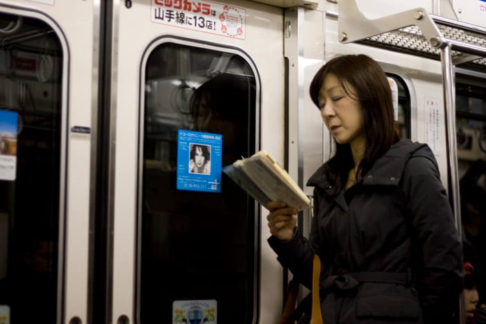 Gente leyendo en el metro de Tokyo