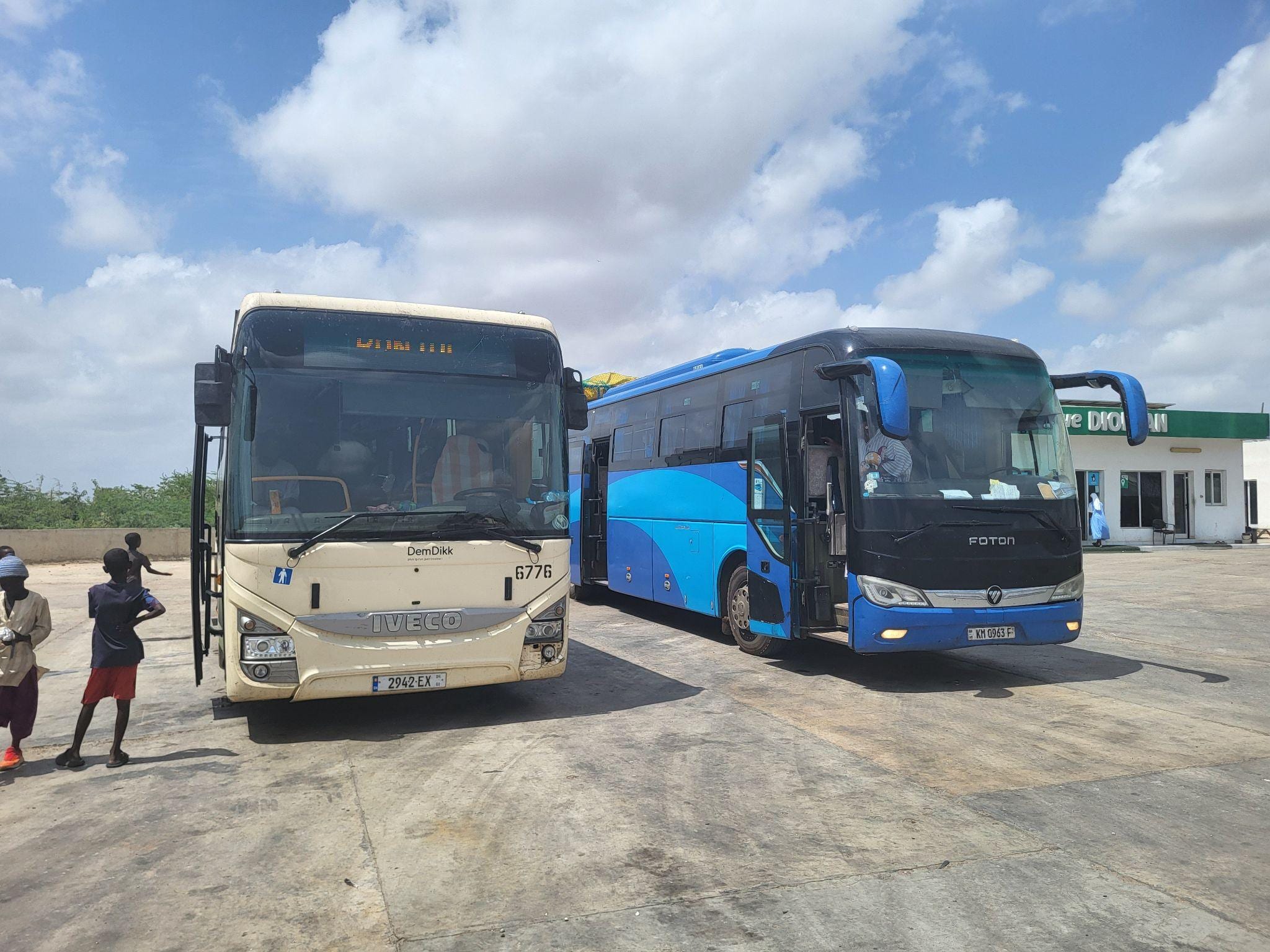 Autobuses de GTSC (Gambia, Azul) y de DemDikk (Senegal) en la parada de descanso a mitad de trayecto