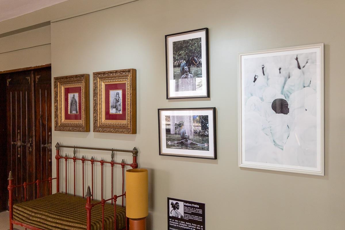 Retratos antiguos en marcos dorados y obra contemporánea en una de las habitaciones del MuPho