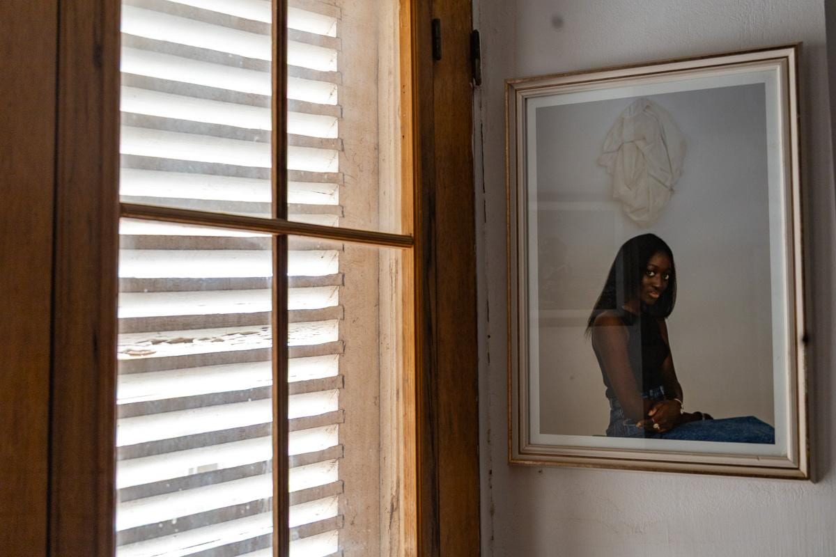 Retrato de gran formato junto a una ventana con contraventanas de madera en el MuPho