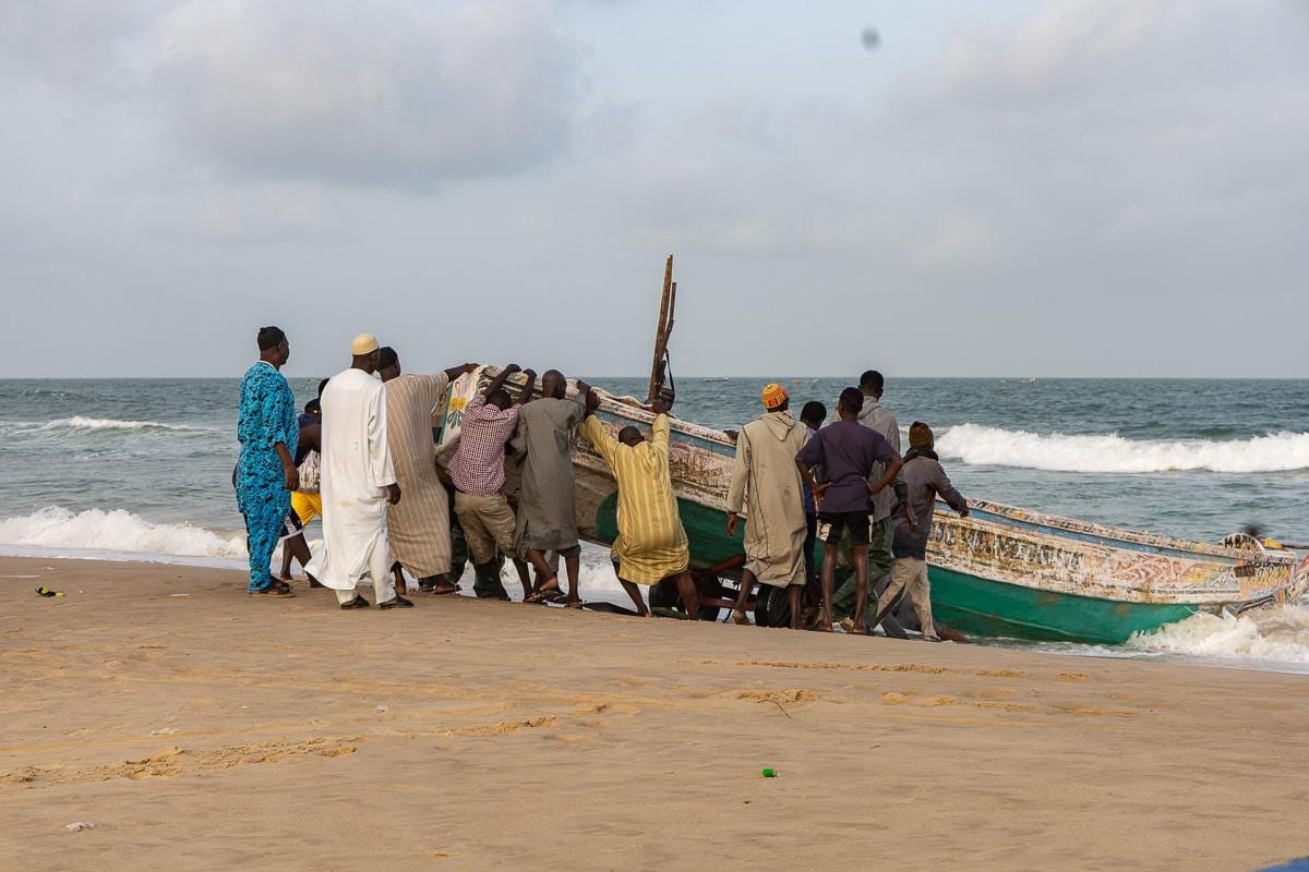 Sacando un barco de pesca del agua, trabajo manual cada día con cientos de pequeñas pirogues