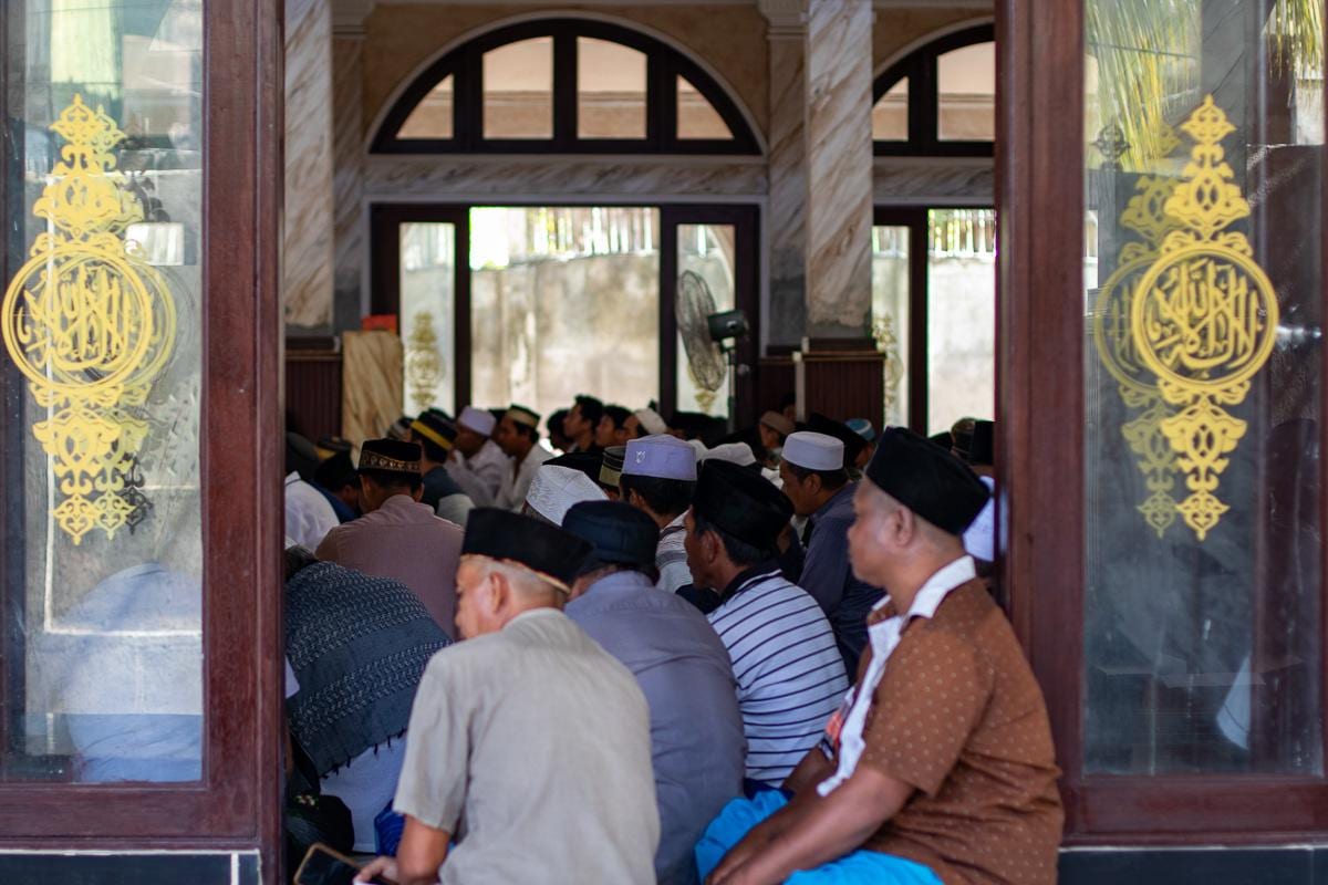 El interior de la mezquita de Gili Trawangan, lleno de hombres sentados en el suelo