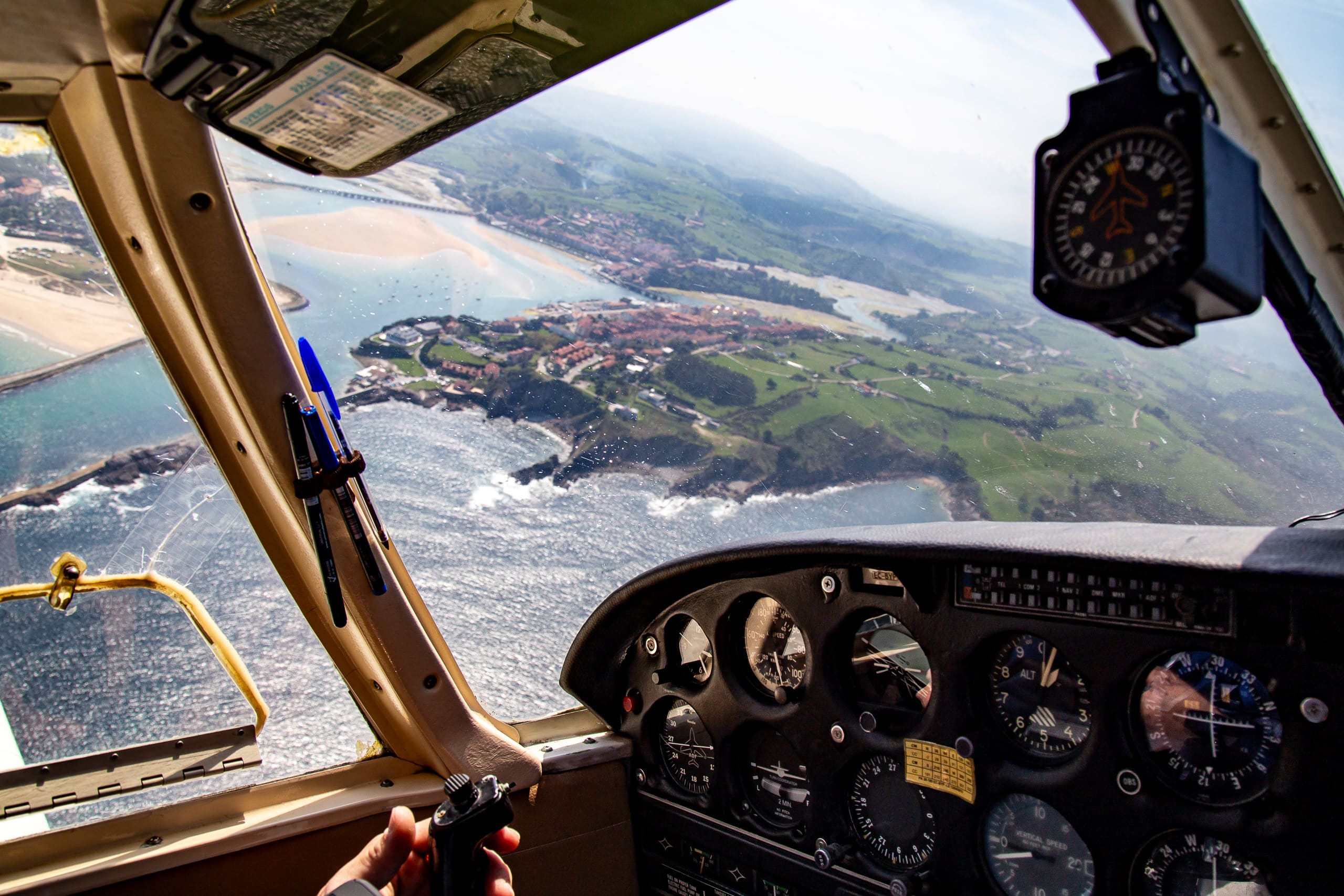San Vicente de la Barquera desde la cabina de una avioneta, con la ría, el puente y la playa de Merón